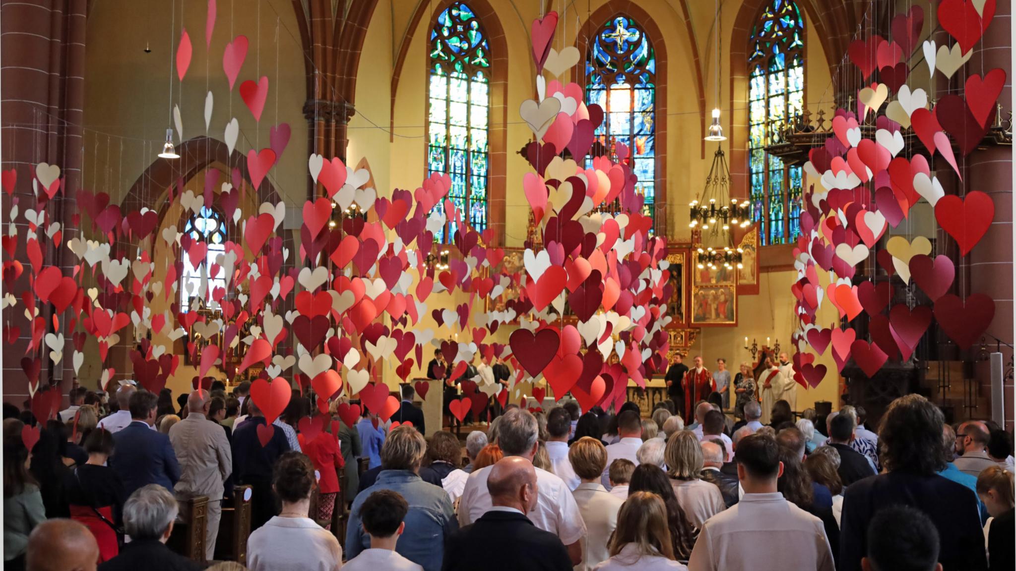 Von der Decke der Heilig-Kreuz-Kirche in Bad Kreuznach hängen hunderte rote Herzen.