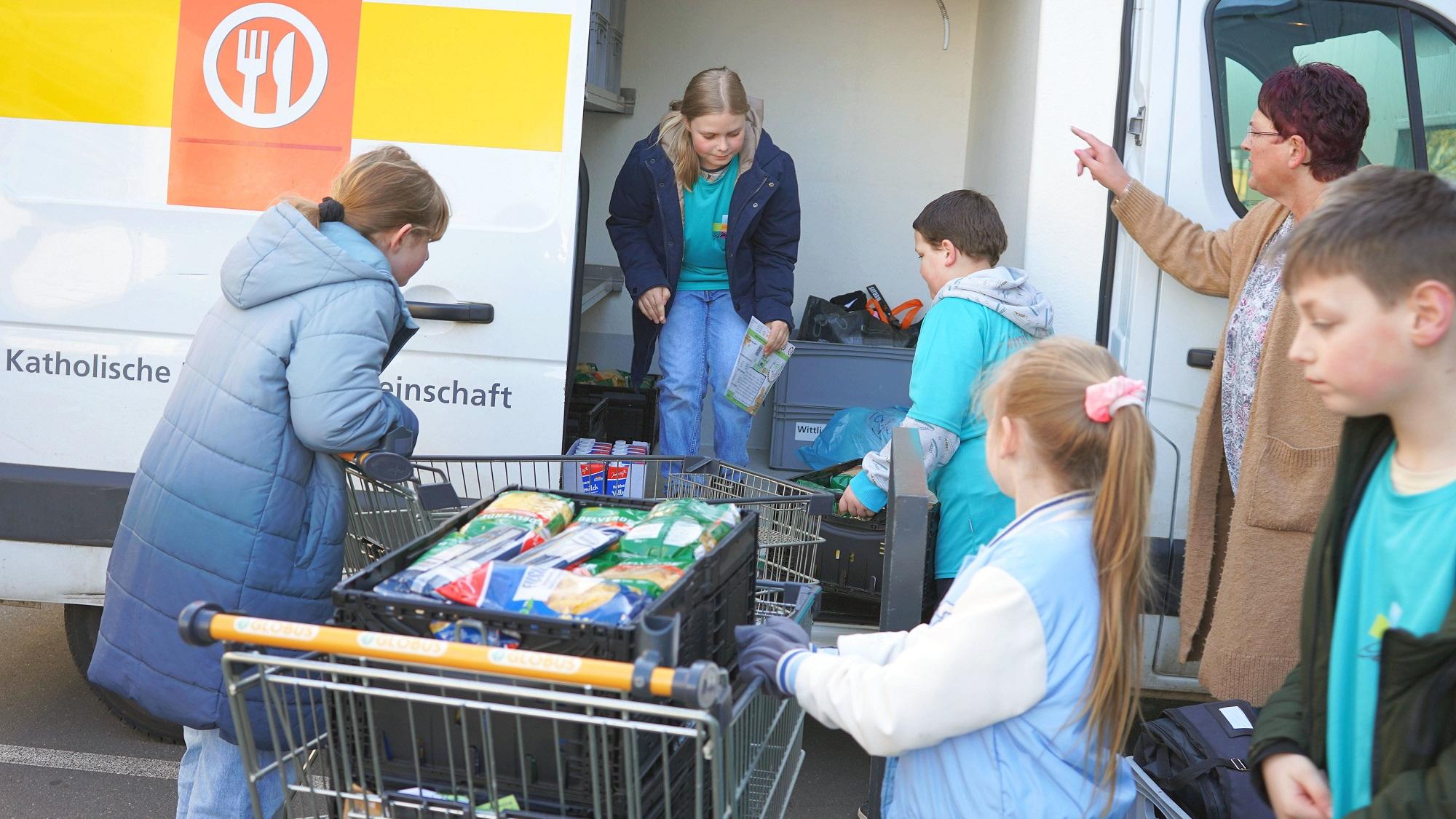 Schülerinnen und Schüler aus Wittlich laden gesammelte Lebensmittel in den „Tafel“-Transporter.